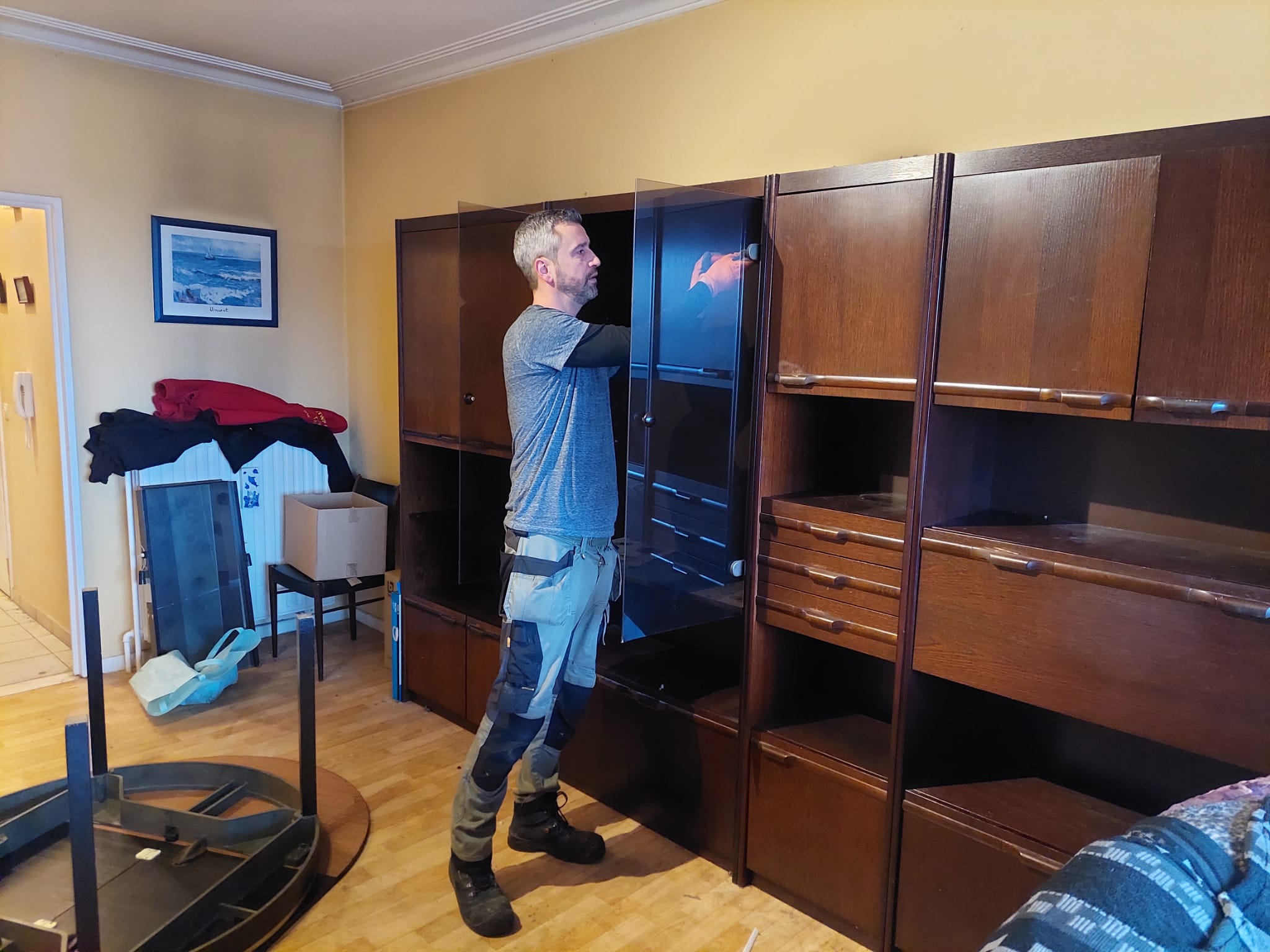 Medewerker van Huisopruimers demonteert een wandkast tijdens het leegmaken van een woning na overlijden